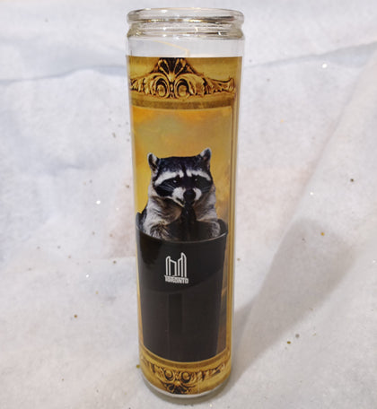 Novelty saint candle with picture of raccoon peeking out of Toronto garbage bin
