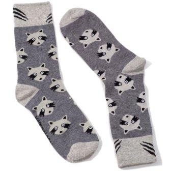 Pair of grey socks with pattern of white and black raccoon faces. White toes, heels and cuffs, with black claw like markings on cuffs. 